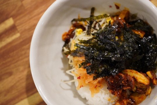 밥 위에 주꾸미볶음과 김가루를 올린 그릇
